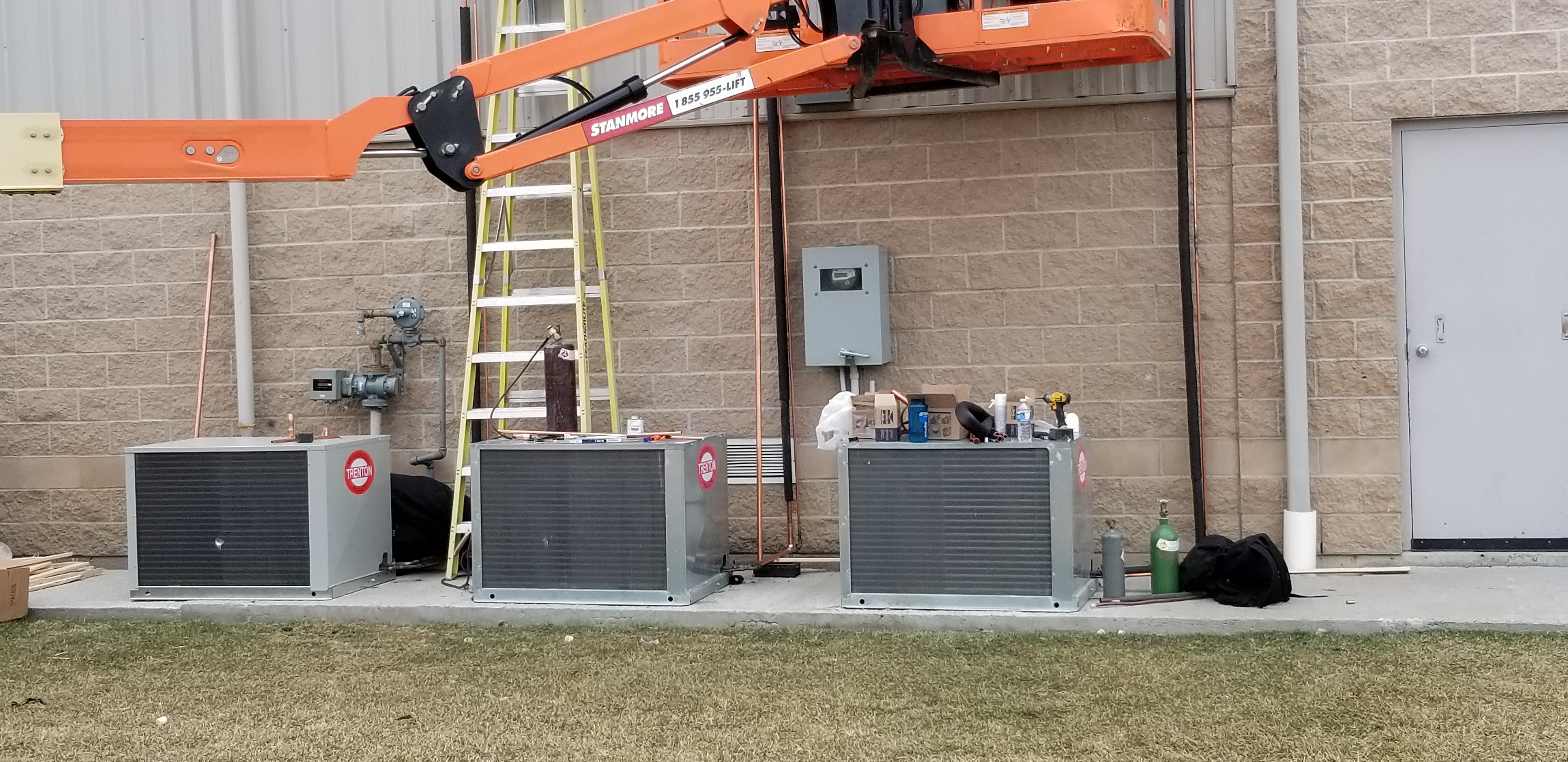HVAC technicians installing condensing units